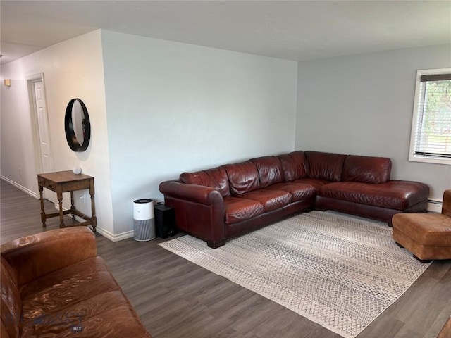 living area featuring dark wood-style flooring, baseboards, and a baseboard radiator