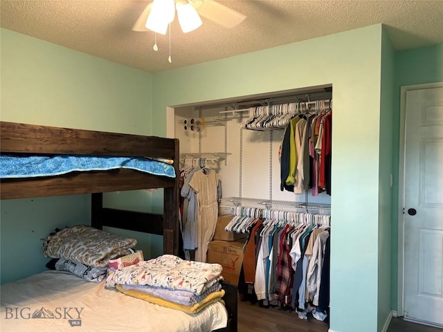 bedroom featuring a closet, wood finished floors, a ceiling fan, and a textured ceiling