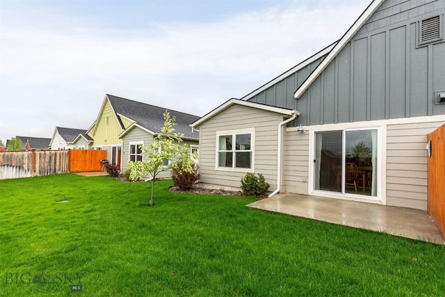 rear view of property with board and batten siding and a patio