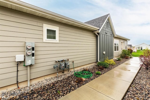 view of side of property featuring board and batten siding and a shingled roof