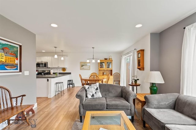living area with light wood-type flooring and recessed lighting