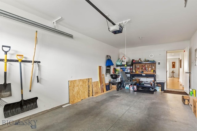 garage with a garage door opener and a workshop area