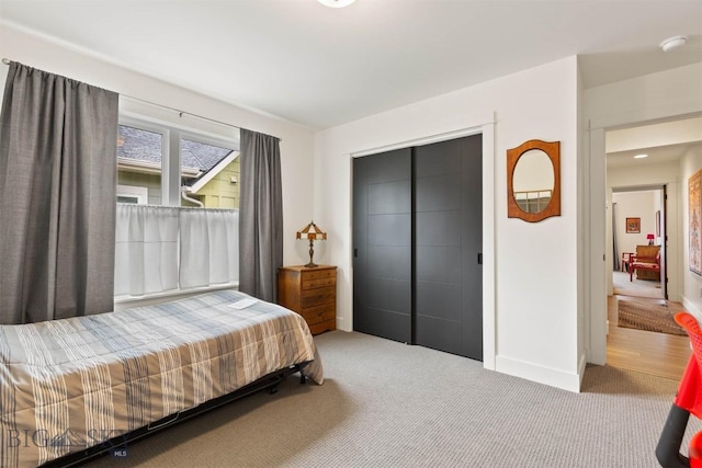 bedroom with carpet flooring, baseboards, and a closet
