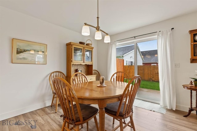 dining area with light wood finished floors and baseboards