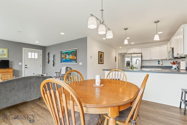 dining room with light wood-style flooring and recessed lighting