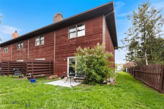 back of house featuring a chimney and a patio area