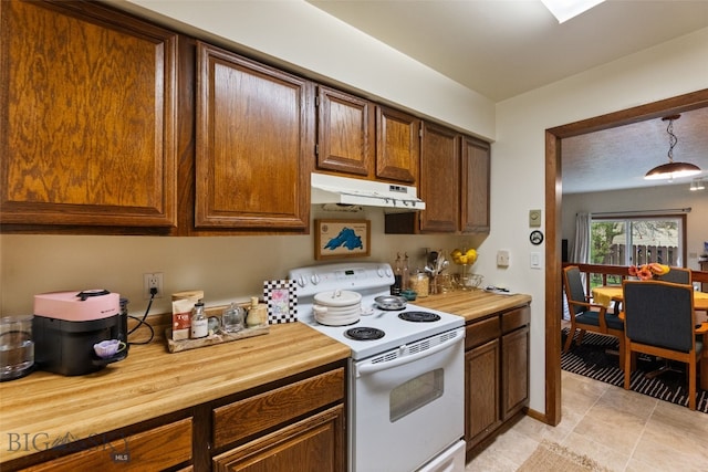 kitchen featuring white range with electric cooktop, under cabinet range hood, butcher block counters, light tile patterned flooring, and hanging light fixtures