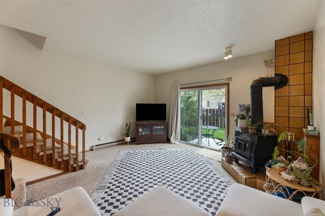 living room with a baseboard heating unit, a wood stove, carpet, and stairs