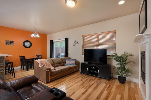 128 Droulliard Ave, Bozeman, MT 59718 - living area featuring light wood-style flooring, a chandelier, recessed lighting, baseboards, and a stone fireplace