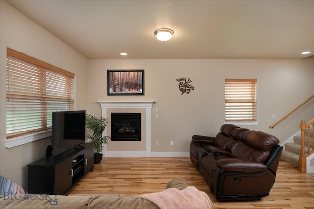 128 Droulliard Ave, Bozeman, MT 59718 - living room with light wood-style floors, stairs, a glass covered fireplace, recessed lighting, and baseboards