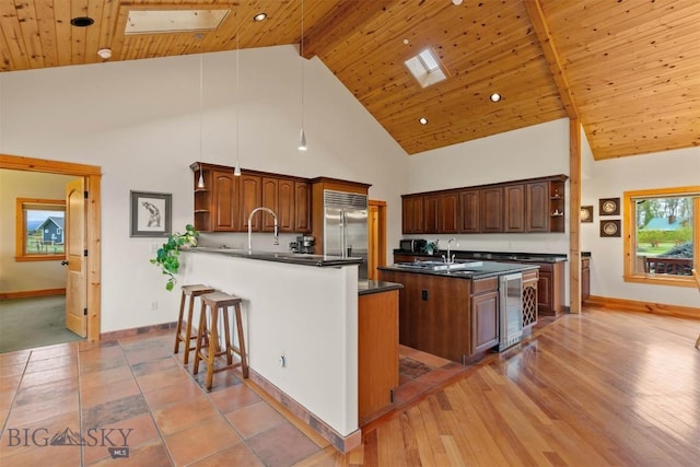 64 Shandalyn Ln, Bozeman, MT 59718 - kitchen with open shelves, built in fridge, dark countertops, wine cooler, and high vaulted ceiling
