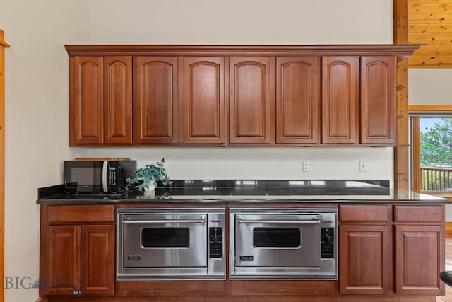 64 Shandalyn Ln, Bozeman, MT 59718 - kitchen with black microwave, dark stone countertops, and brown cabinetry