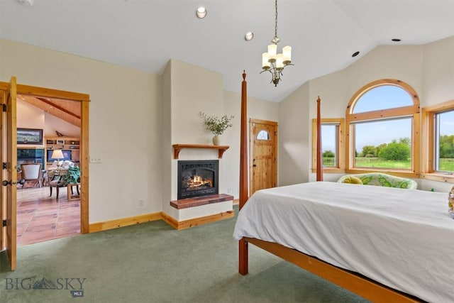 64 Shandalyn Ln, Bozeman, MT 59718 - bedroom with lofted ceiling, a glass covered fireplace, carpet floors, a chandelier, and baseboards