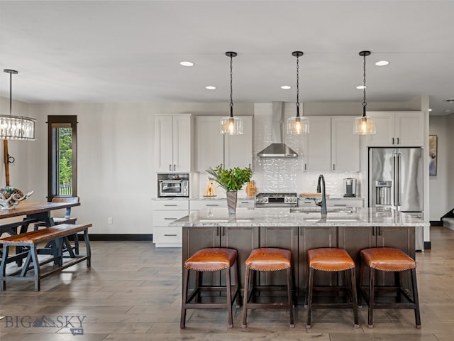 449 Minni Hall Rd, Bozeman, MT 59715 - kitchen with wall chimney range hood, white cabinets, a center island with sink, recessed lighting, and a sink