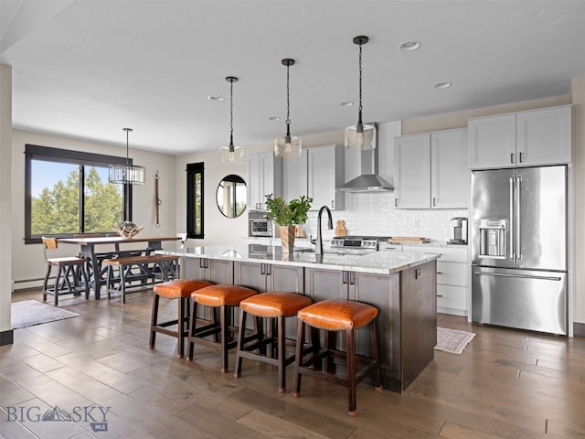 449 Minni Hall Rd, Bozeman, MT 59715 - kitchen with high end refrigerator, wall chimney exhaust hood, an island with sink, healthy amount of natural light, and recessed lighting