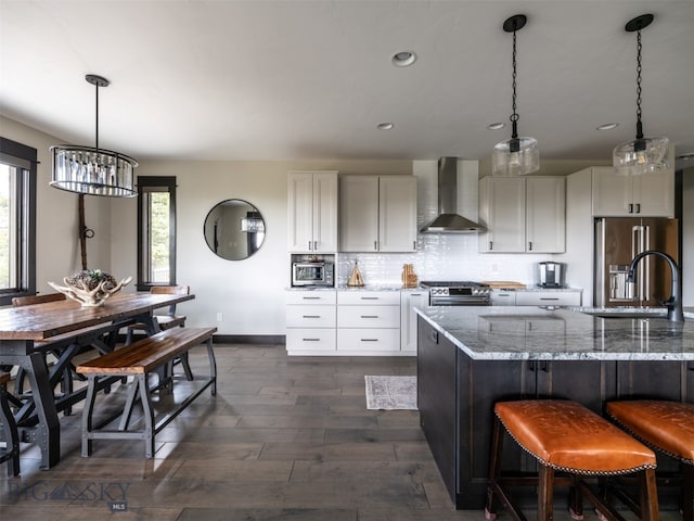 449 Minni Hall Rd, Bozeman, MT 59715 - kitchen with wall chimney exhaust hood, appliances with stainless steel finishes, dark wood-style floors, light stone counters, and white cabinetry