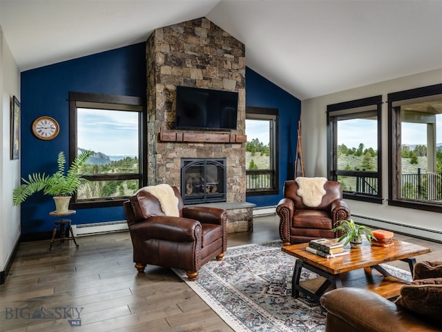 449 Minni Hall Rd, Bozeman, MT 59715 - living room with vaulted ceiling, a baseboard radiator, a stone fireplace, wood finished floors, and a baseboard heating unit
