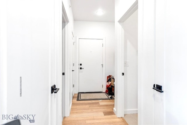 hall with light wood finished floors and baseboards