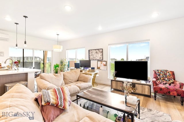 living room featuring light wood-style floors, recessed lighting, and an AC wall unit