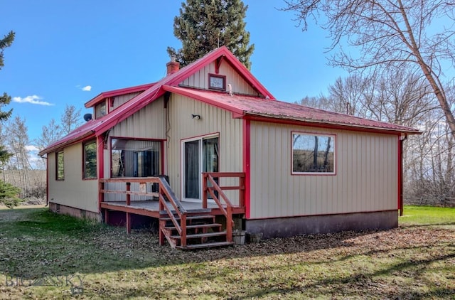 185 Elk Creek Rd N, Wilsall, MT 59086 - view of front of home featuring a wooden deck, a chimney, metal roof, and a front lawn