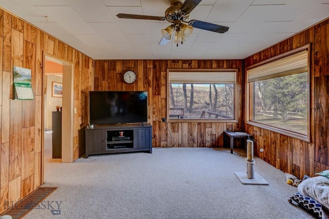 185 Elk Creek Rd N, Wilsall, MT 59086 - living area featuring wooden walls, carpet, healthy amount of natural light, and a ceiling fan