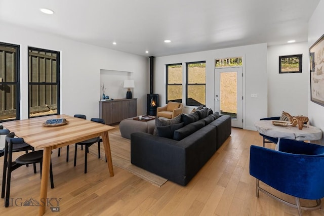 living area featuring a wood stove, light wood finished floors, and recessed lighting
