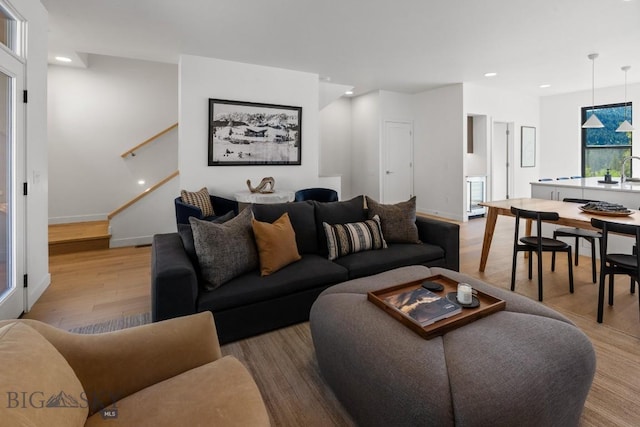 living area with wood finished floors, stairway, baseboards, and recessed lighting