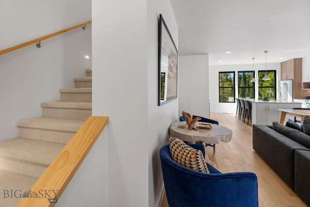 living area with light wood-style floors, stairway, and recessed lighting