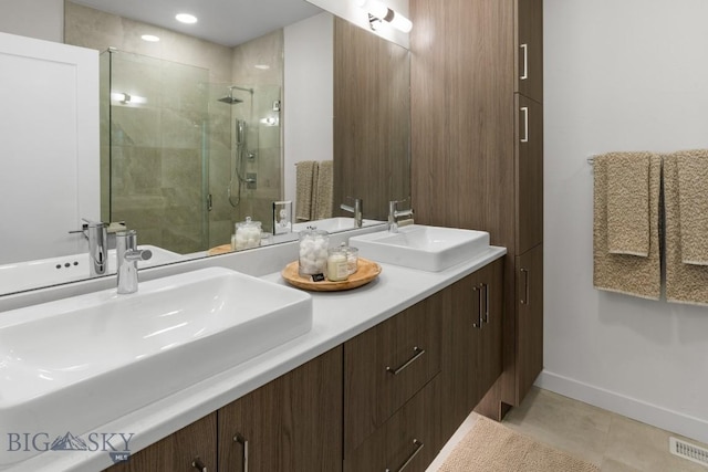 full bathroom featuring a shower stall, tile patterned flooring, double vanity, and baseboards