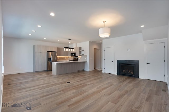 3030 Autumn Grove St Unit C, Bozeman, MT 59718 - unfurnished living room featuring light wood-style flooring, recessed lighting, a fireplace, and baseboards