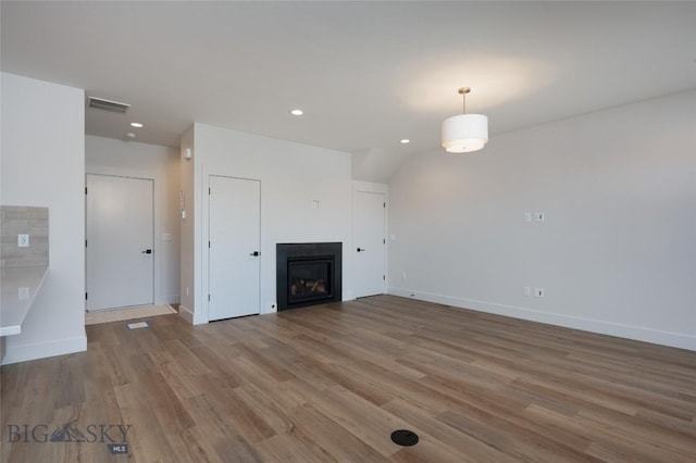 3030 Autumn Grove St Unit C, Bozeman, MT 59718 - unfurnished living room featuring wood finished floors, recessed lighting, baseboards, and a glass covered fireplace