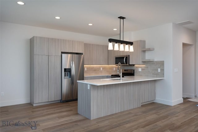 3030 Autumn Grove St Unit C, Bozeman, MT 59718 - kitchen featuring appliances with stainless steel finishes, modern cabinets, a peninsula, light countertops, and decorative backsplash