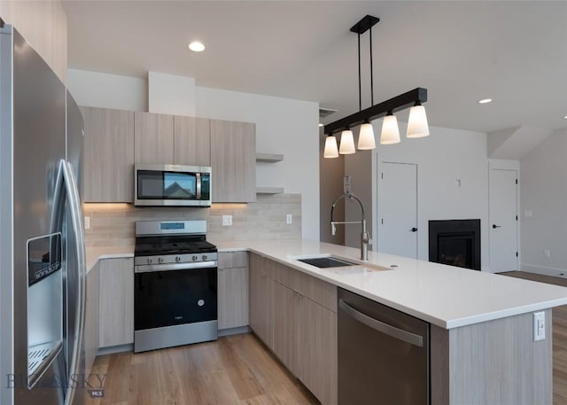 3030 Autumn Grove St Unit C, Bozeman, MT 59718 - kitchen with appliances with stainless steel finishes, modern cabinets, a sink, a peninsula, and tasteful backsplash