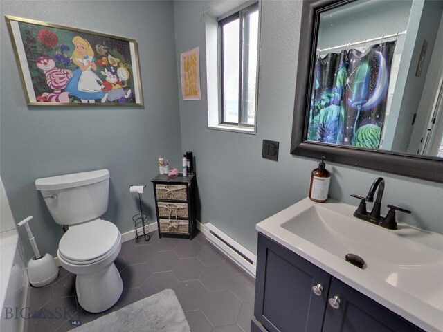 902 E Gallatin Ave, Belgrade, MT 59714 - full bathroom featuring a baseboard radiator, toilet, tile patterned floors, vanity, and baseboards
