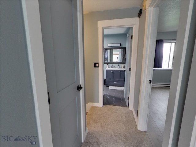 902 E Gallatin Ave, Belgrade, MT 59714 - hallway featuring light colored carpet, a baseboard heating unit, and baseboards