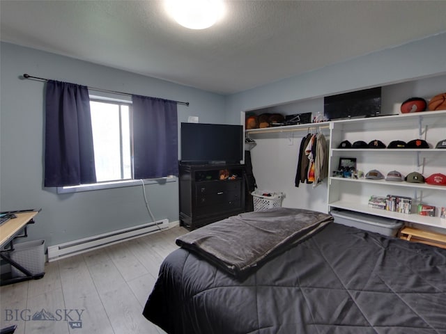 902 E Gallatin Ave, Belgrade, MT 59714 - bedroom featuring baseboard heating, wood finished floors, baseboards, and a closet