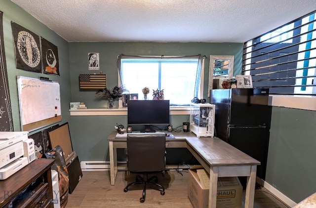 902 E Gallatin Ave, Belgrade, MT 59714 - office with a textured ceiling, wood finished floors, a baseboard radiator, and baseboards