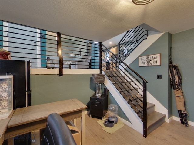 902 E Gallatin Ave, Belgrade, MT 59714 - staircase featuring wood finished floors, a textured ceiling, and baseboards