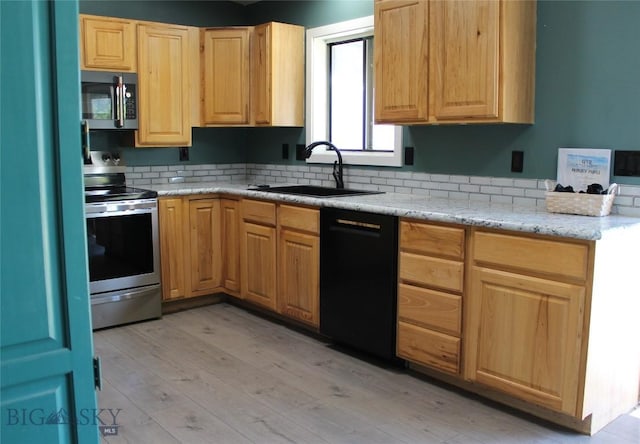 902 E Gallatin Ave, Belgrade, MT 59714 - kitchen with appliances with stainless steel finishes, light wood-style floors, light brown cabinets, light stone counters, and backsplash