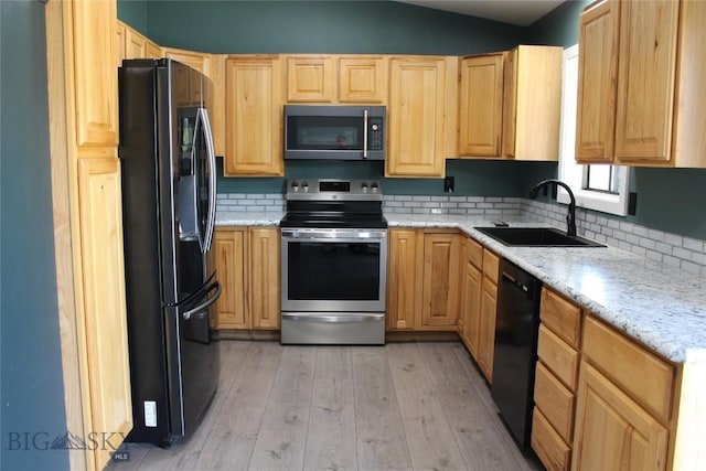 902 E Gallatin Ave, Belgrade, MT 59714 - kitchen with black appliances, light brown cabinetry, light wood-style flooring, decorative backsplash, and lofted ceiling