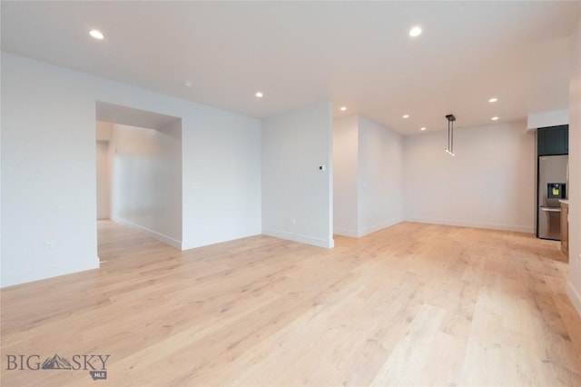 unfurnished room with recessed lighting, light wood-style flooring, and baseboards