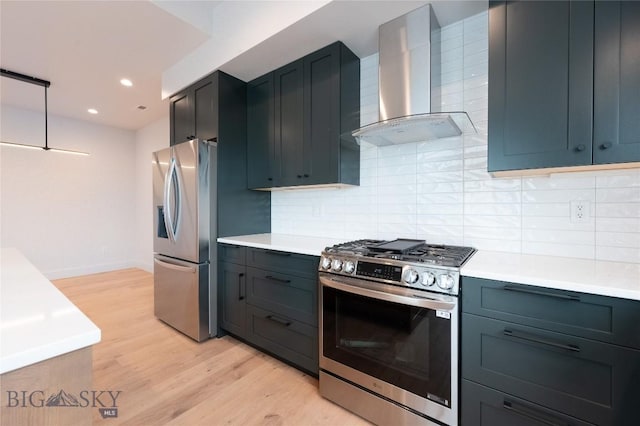 kitchen with stainless steel appliances, wall chimney exhaust hood, light wood-style floors, decorative backsplash, and light countertops