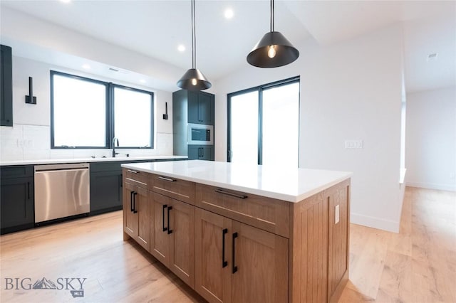 kitchen featuring stainless steel appliances, healthy amount of natural light, a sink, decorative backsplash, and recessed lighting