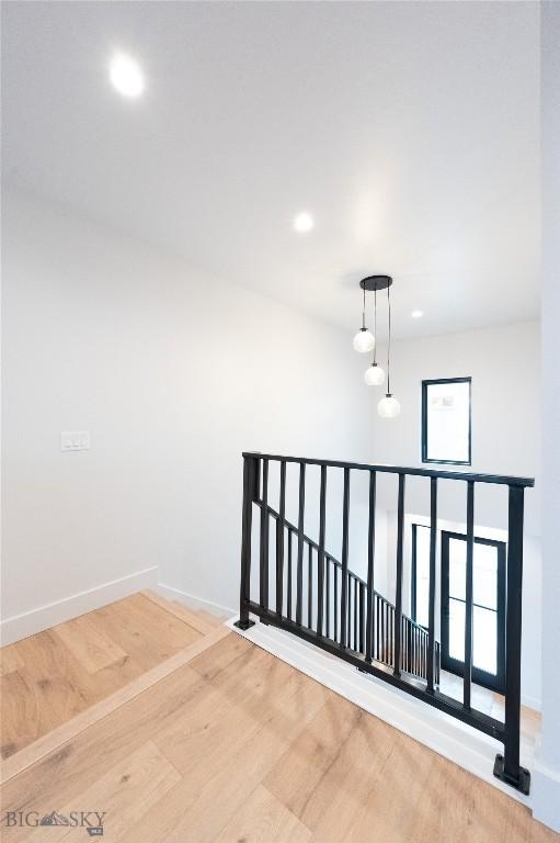 stairway featuring wood finished floors, baseboards, and recessed lighting