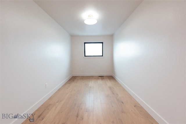 spare room featuring light wood-type flooring and baseboards