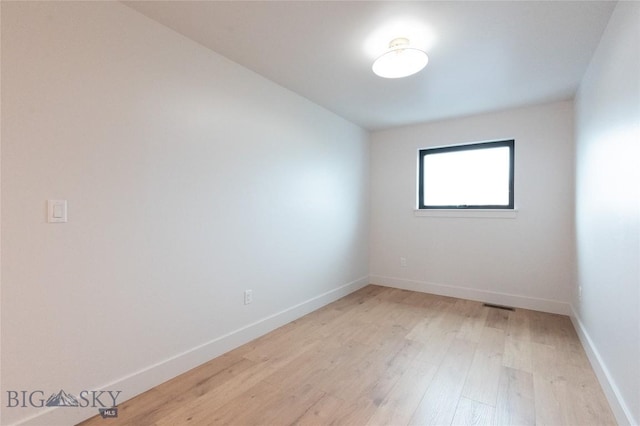 spare room featuring light wood-style flooring and baseboards