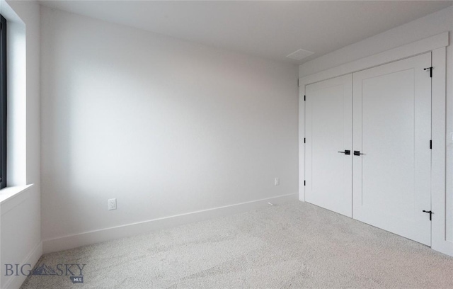 unfurnished bedroom featuring carpet floors, a closet, and baseboards