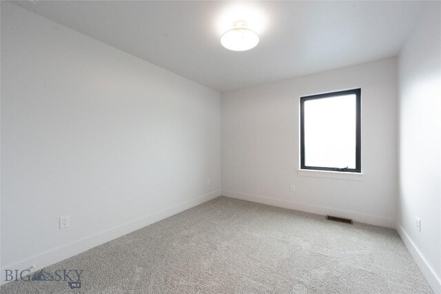 spare room with light colored carpet and baseboards