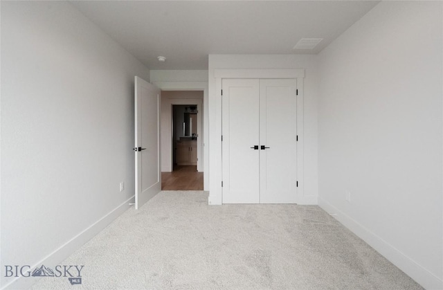 unfurnished bedroom featuring carpet flooring, baseboards, and a closet