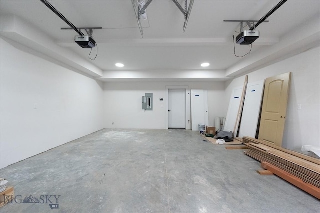 garage with a garage door opener, electric panel, and recessed lighting